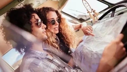 Young couple on a road trip looking at a map