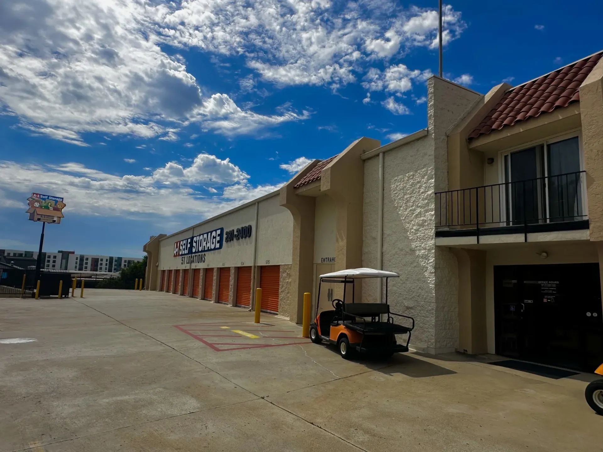 Front of building with office entrance, golf cart, A-1 Self Storage sign, and drive-up units. 