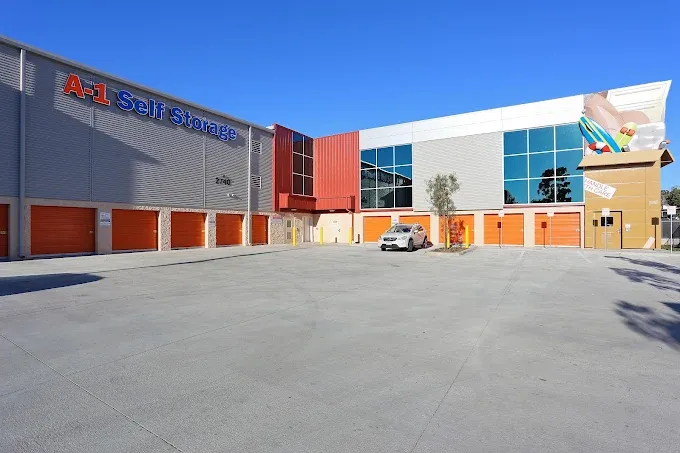 Back side of the facility with drive-up units, a large driving area, and parking