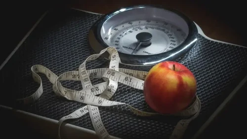 Scale, measuring tape, and an apple